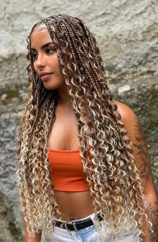 Waist-length knotless braids with caramel highlights and loose curled ends